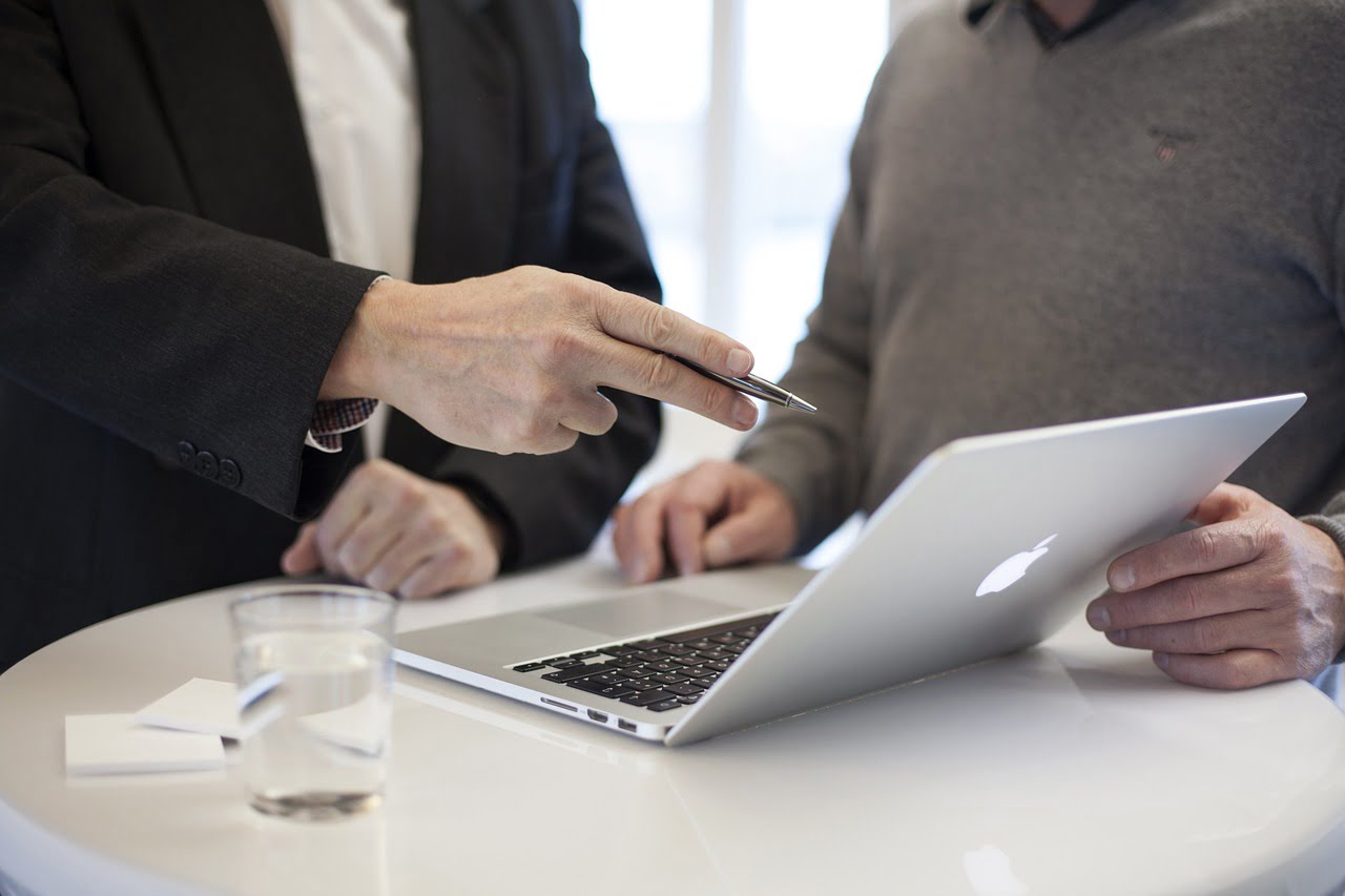 A lawyer pointing at a laptop while discussing a client matter