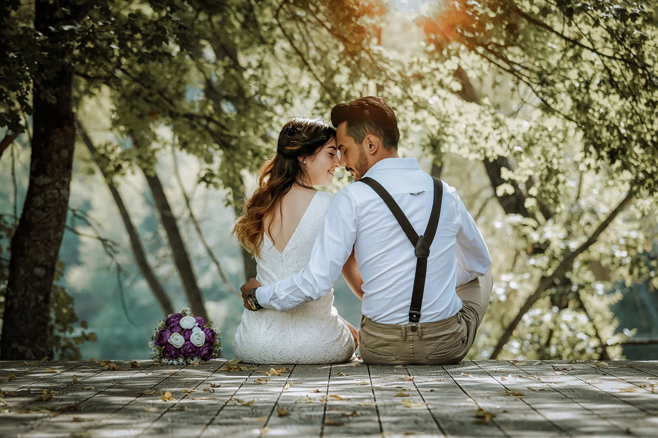 A married couple sitting together in a wooded park