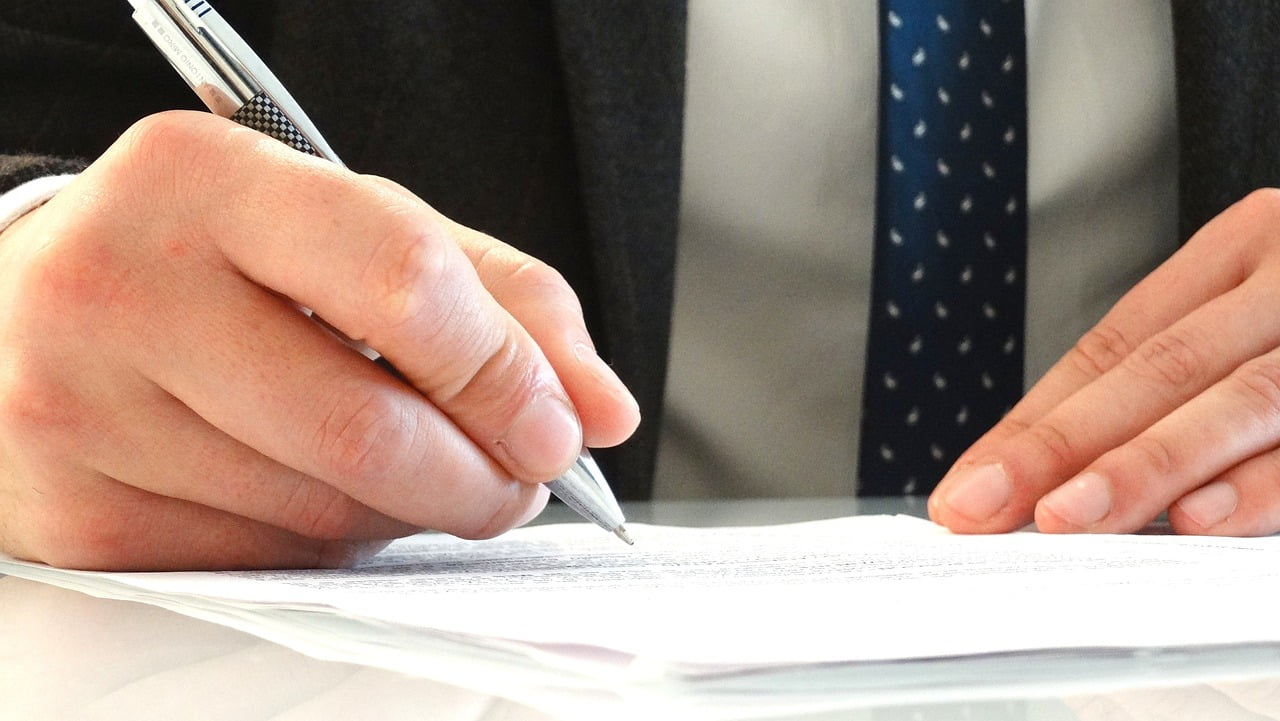 Pen poised over a custom-drafted agreement