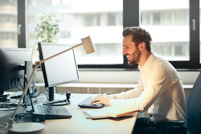 A confident professional smiling at a sunlit desk — agreements that hold up